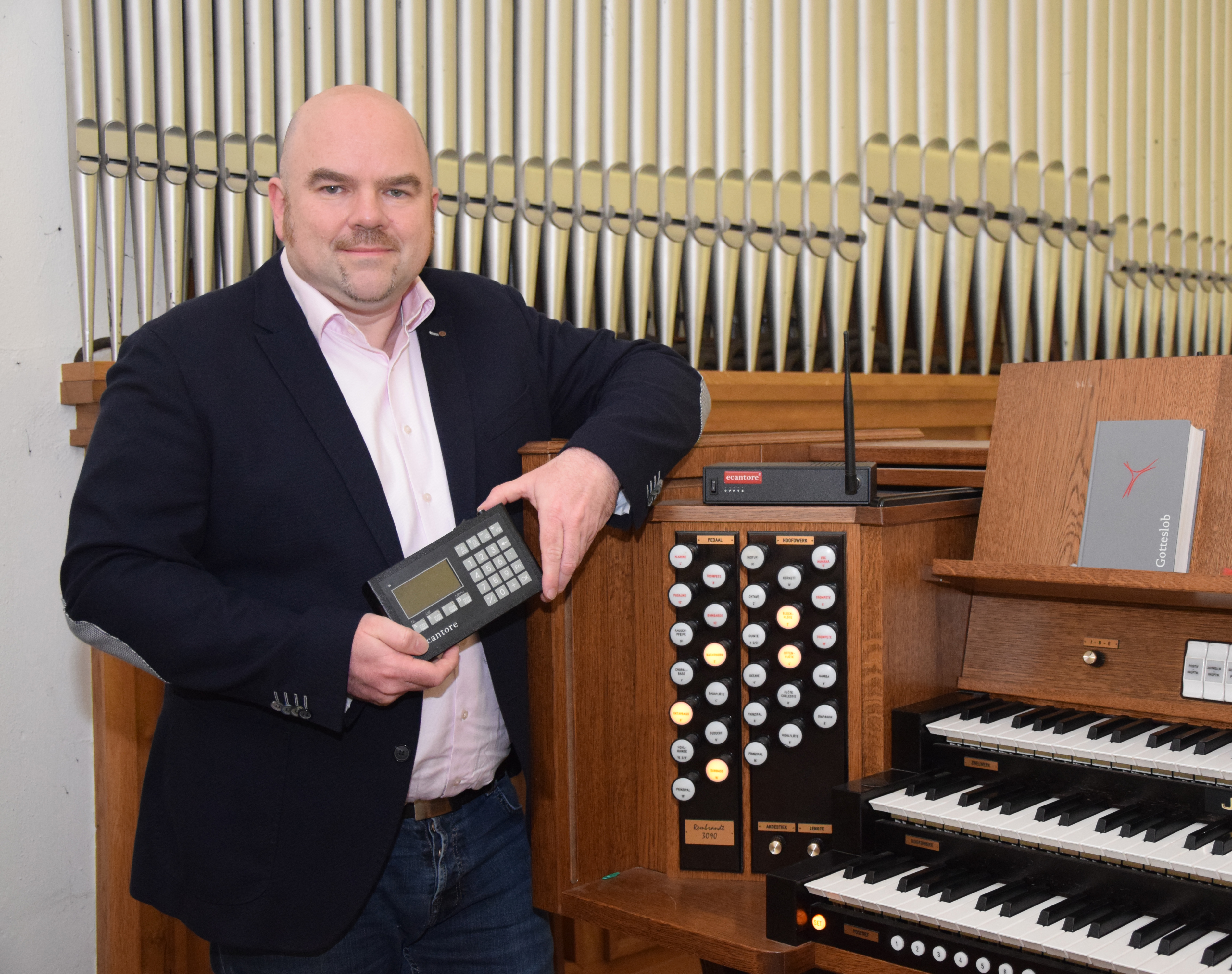 Stephan Renkens, Entwickler von ecantore, an einer Kirchenorgel mit der ecantore Fernbedienung